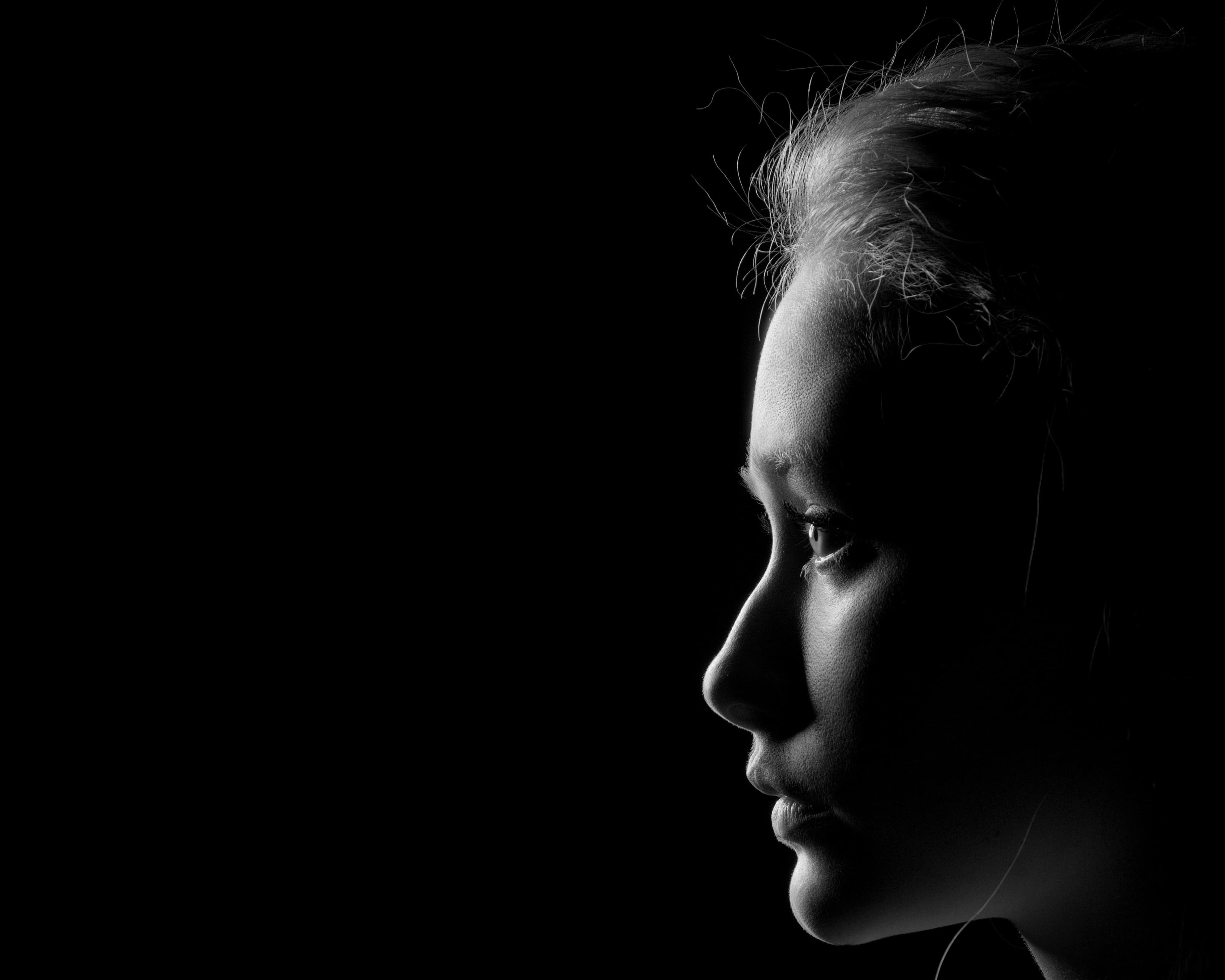 Black and white portrait of a woman with studio lighting, looking to the side.